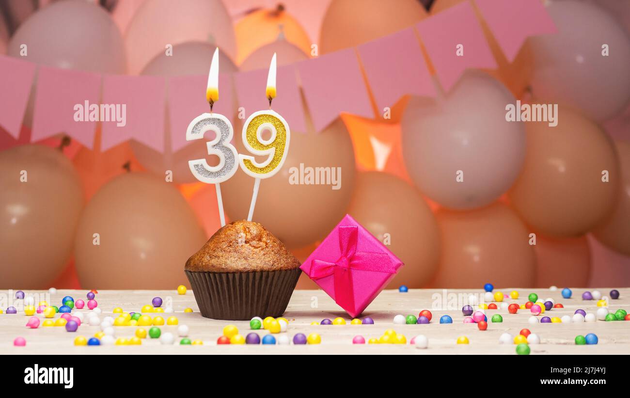 Ballondekorationen und eine Geburtstagskerze mit einer Nummer in einem Kuchen. Alles gute zum Geburtstag Grüße in rosa Farben für ein Mädchen, Platz kopieren. Muffin Stockfoto