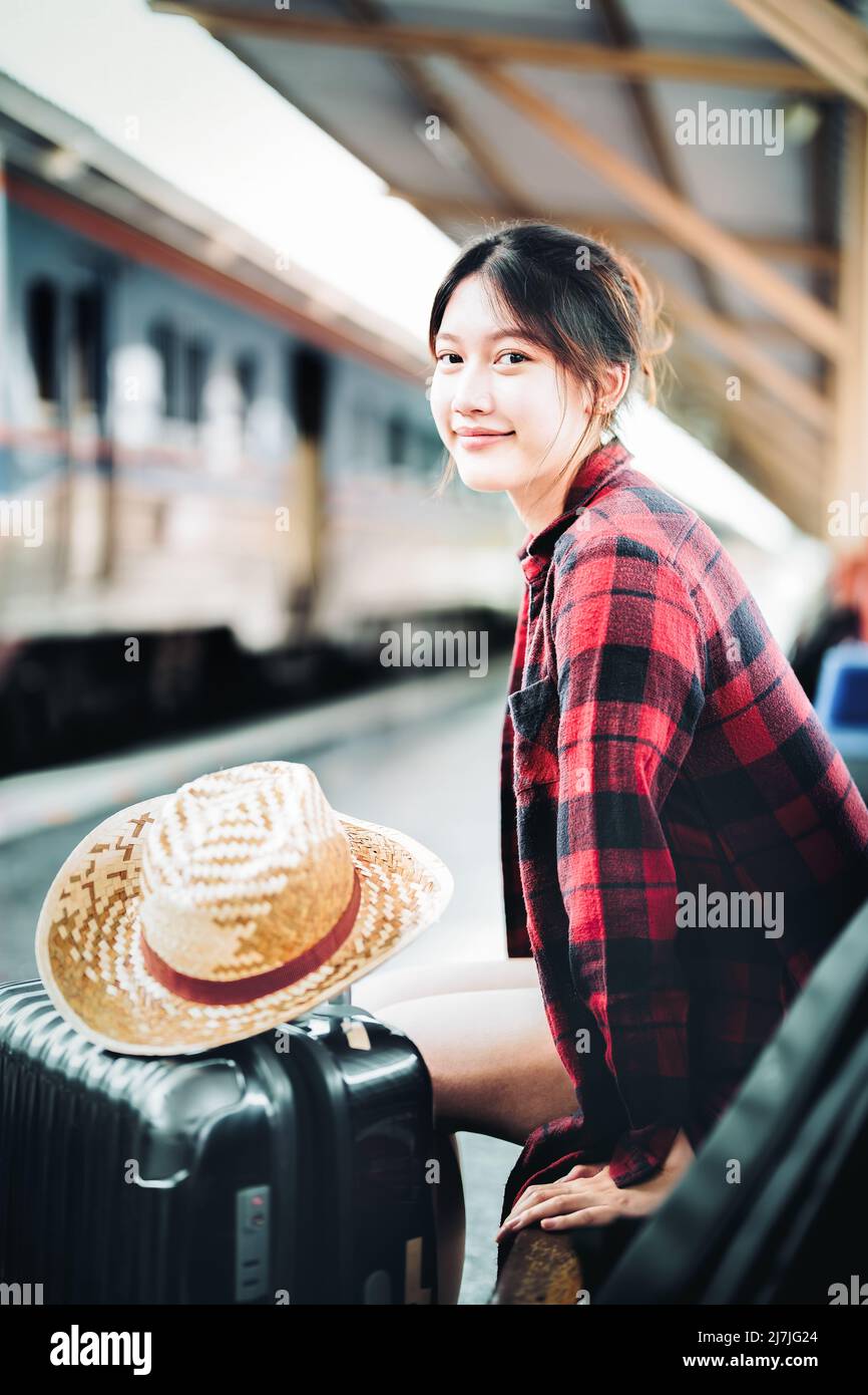 Sommer, entspannen, Urlaub, Reisen, Porträt von niedlichen asiatischen Mädchen zeigt Lächeln und wartet am Bahnhof für einen Sommerurlaub. Stockfoto