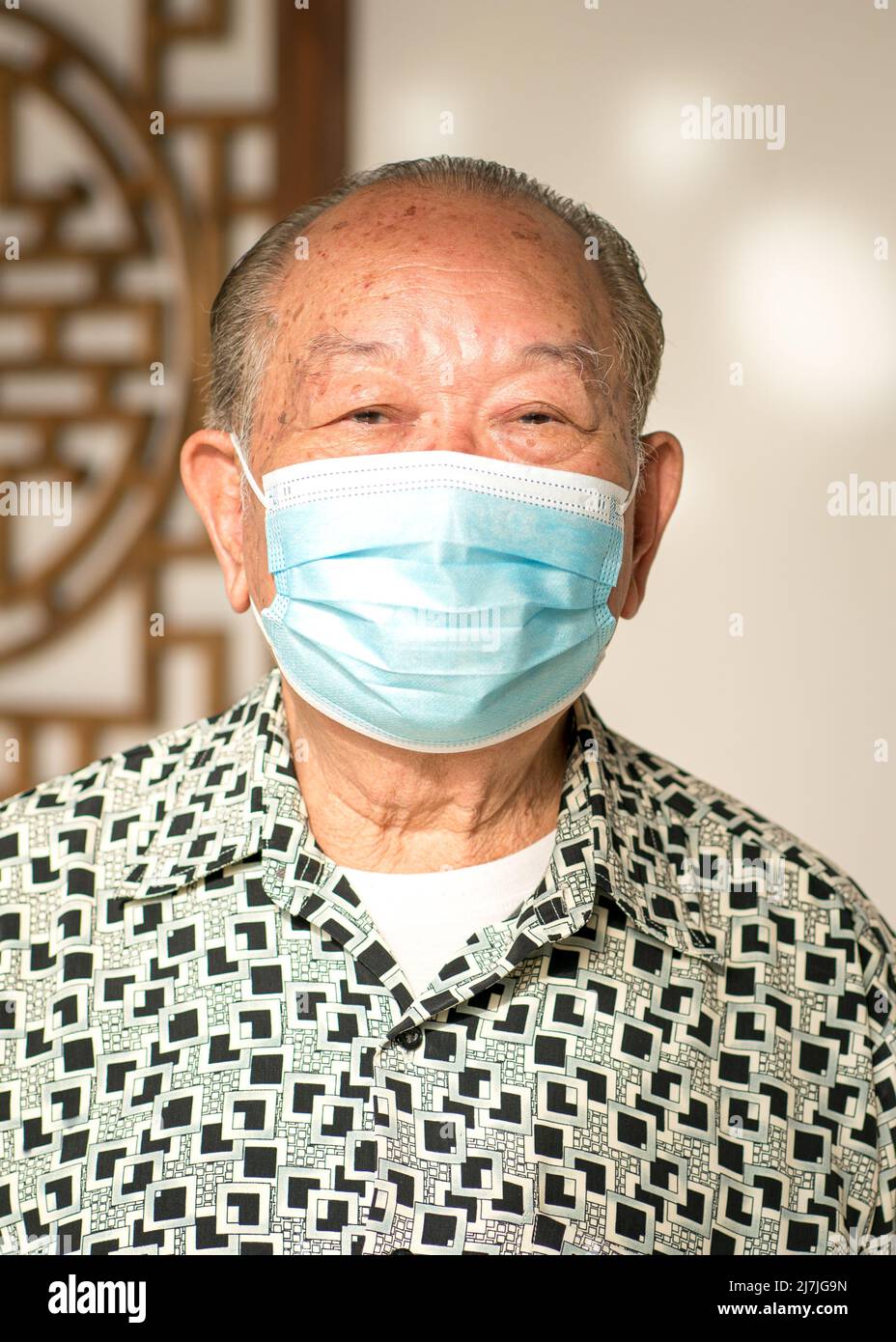 Älterer asiatischer Mann, chinesische Ethnie. Medizinische Gesichtsmaske tragen. Porträt, Nahaufnahme. Stockfoto