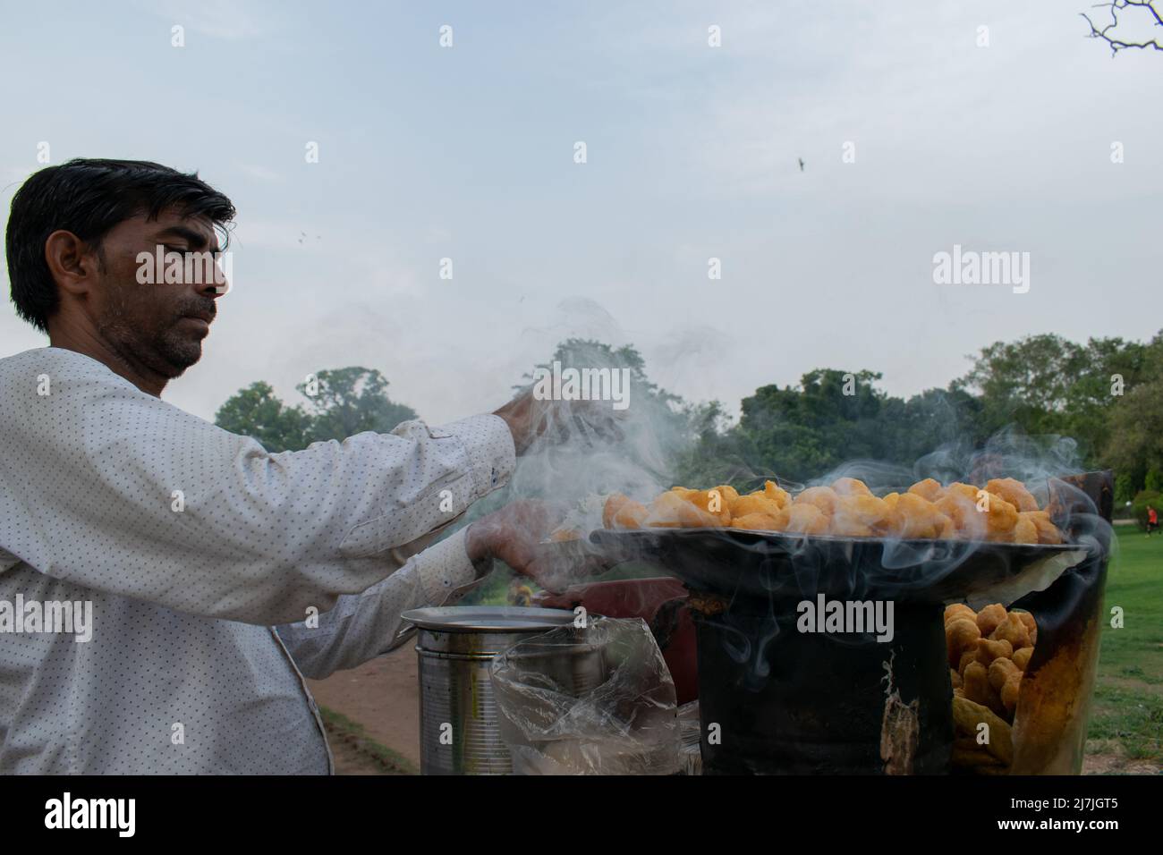 Ein indischer Mann macht Straßenessen im Freien. Stockfoto