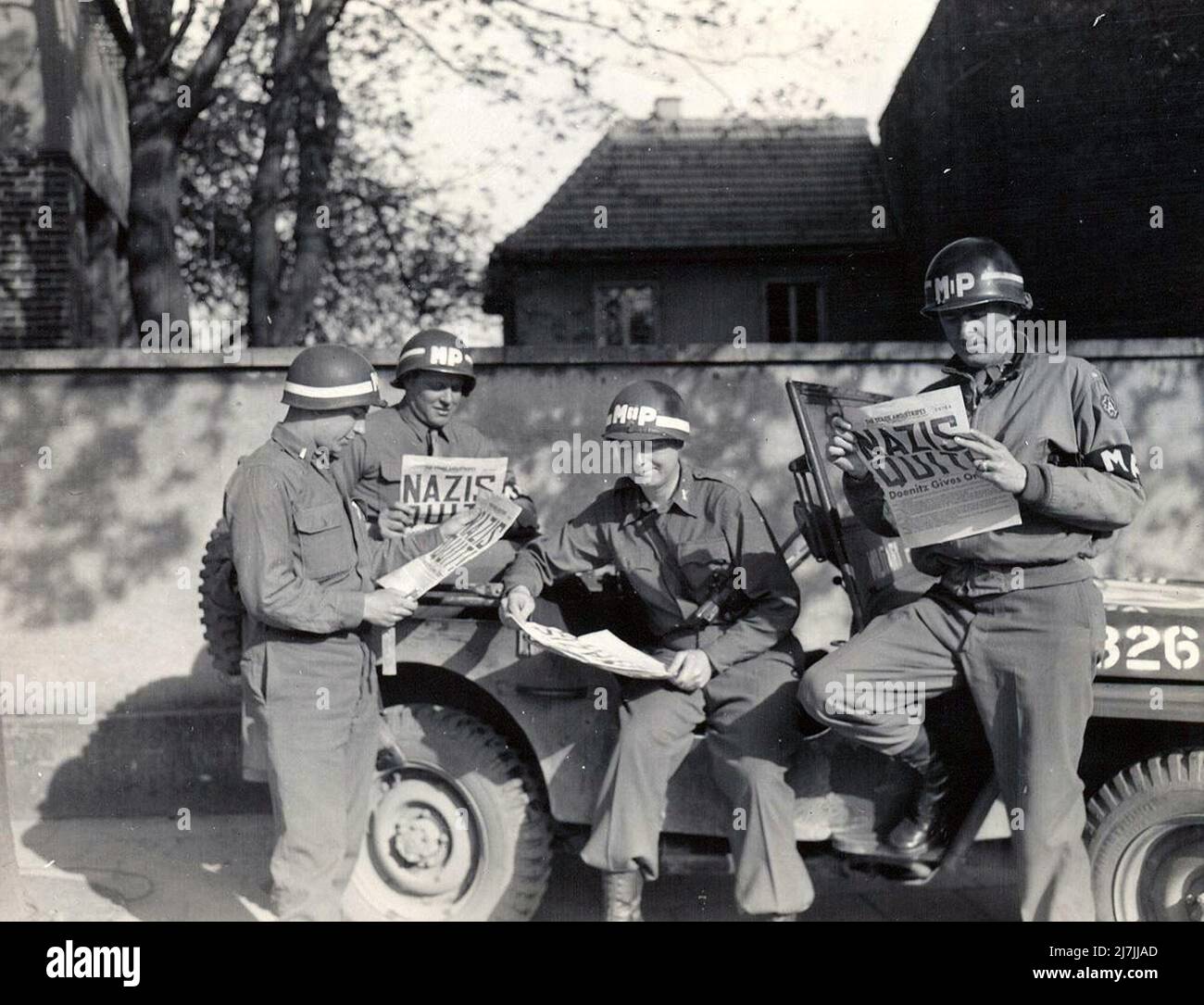 US-Militärpolizisten lasen über die deutsche Kapitulation, die den Zweiten Weltkrieg in Europa beendete. Stockfoto