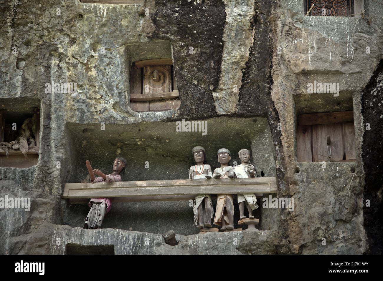 Steingrabeöffnungen und Holzraster auf einer Klippe an einer traditionellen Grabstätte in Lemo, Nord-Toraja, Süd-Sulawesi, Indonesien. Stockfoto