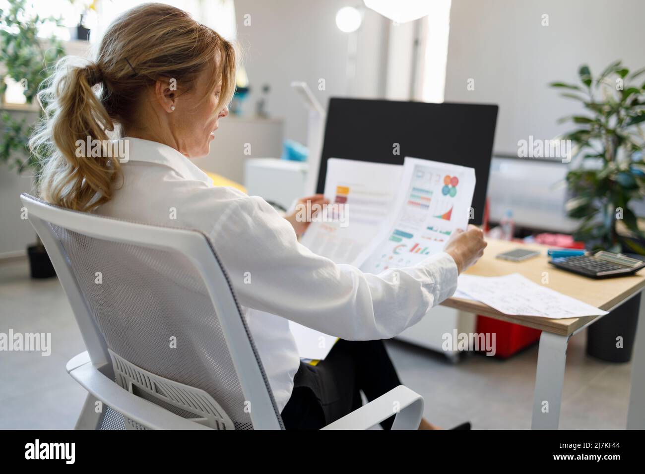 Geschäftsfrau mittleren Alters schauen Finanzbericht analysieren Einkommen Stockfoto