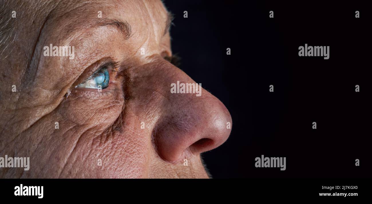 Nahaufnahme, Makrofoto einer älteren Frau mit farbigen Augen, Iris, Pupille, Wimpern, Augenlidern. Hochwertige Fotos Stockfoto