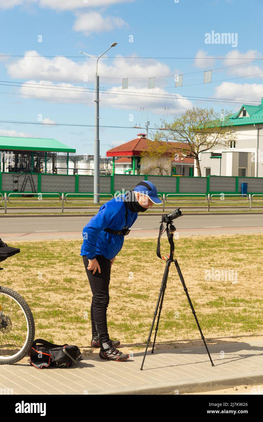 Straßenfotograf mit Kamera und Stativ, der Stadtlandschaften fotografiert. Reisefotograf nimmt spiegellose Zeitraffer-Kamera auf Stativ auf. Stockfoto