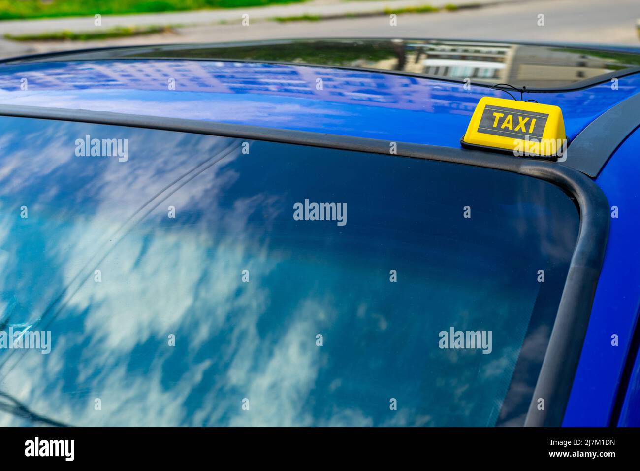 Yellow Chip Taxi auf dem Dach eines blauen Autos. Stockfoto