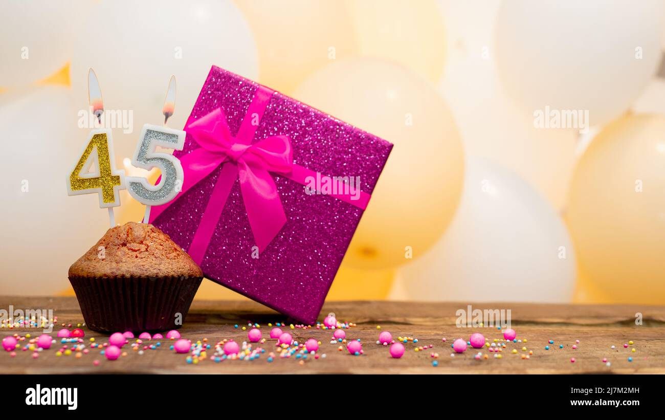 Alles gute zum Geburtstag mit rosa Geschenkbox für Baby Mädchen. Schöne Geburtstagskarte mit einem Cupcake und einer brennenden Kerze Stockfoto