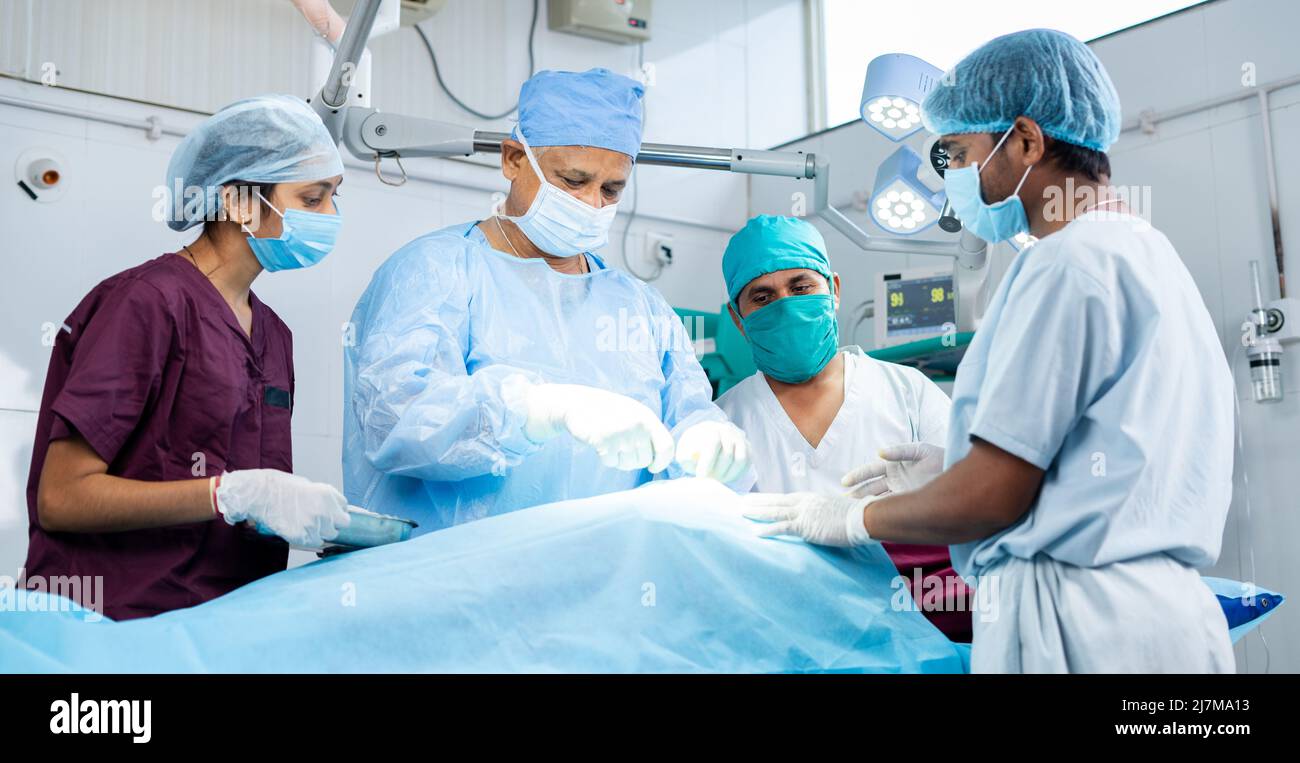 Gruppe von Chirurgen, die am Operationssaal eine Operation am Patienten machen - Konzept der Teamarbeit, Gesundheitsversorgung oder Medizin und Behandlung Stockfoto