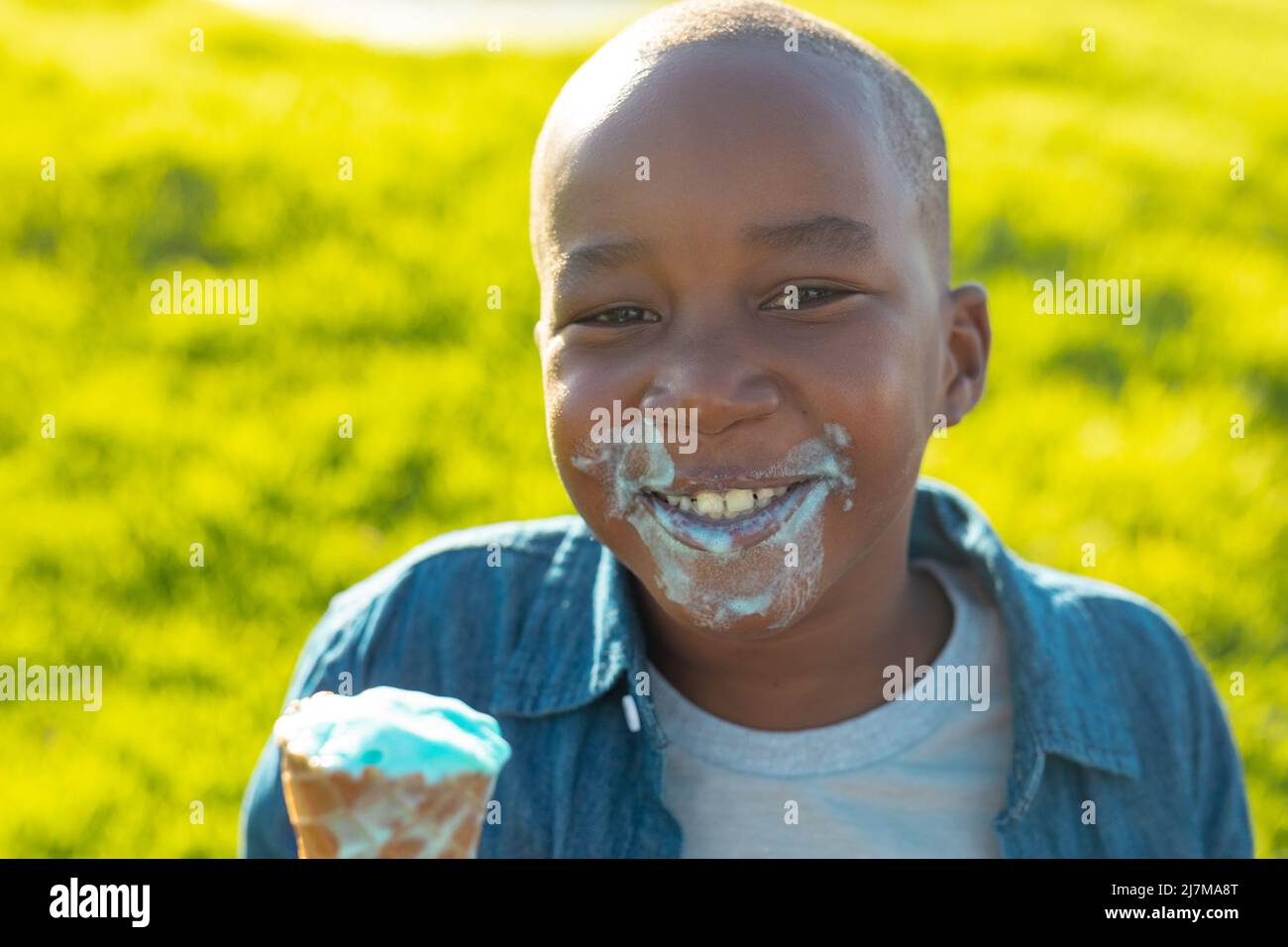 Porträt eines glücklichen afroamerikanischen Jungen mit einem chaotischen Gesicht, das im Sommer beim Essen von schmelzendem Eis zu sehen war Stockfoto