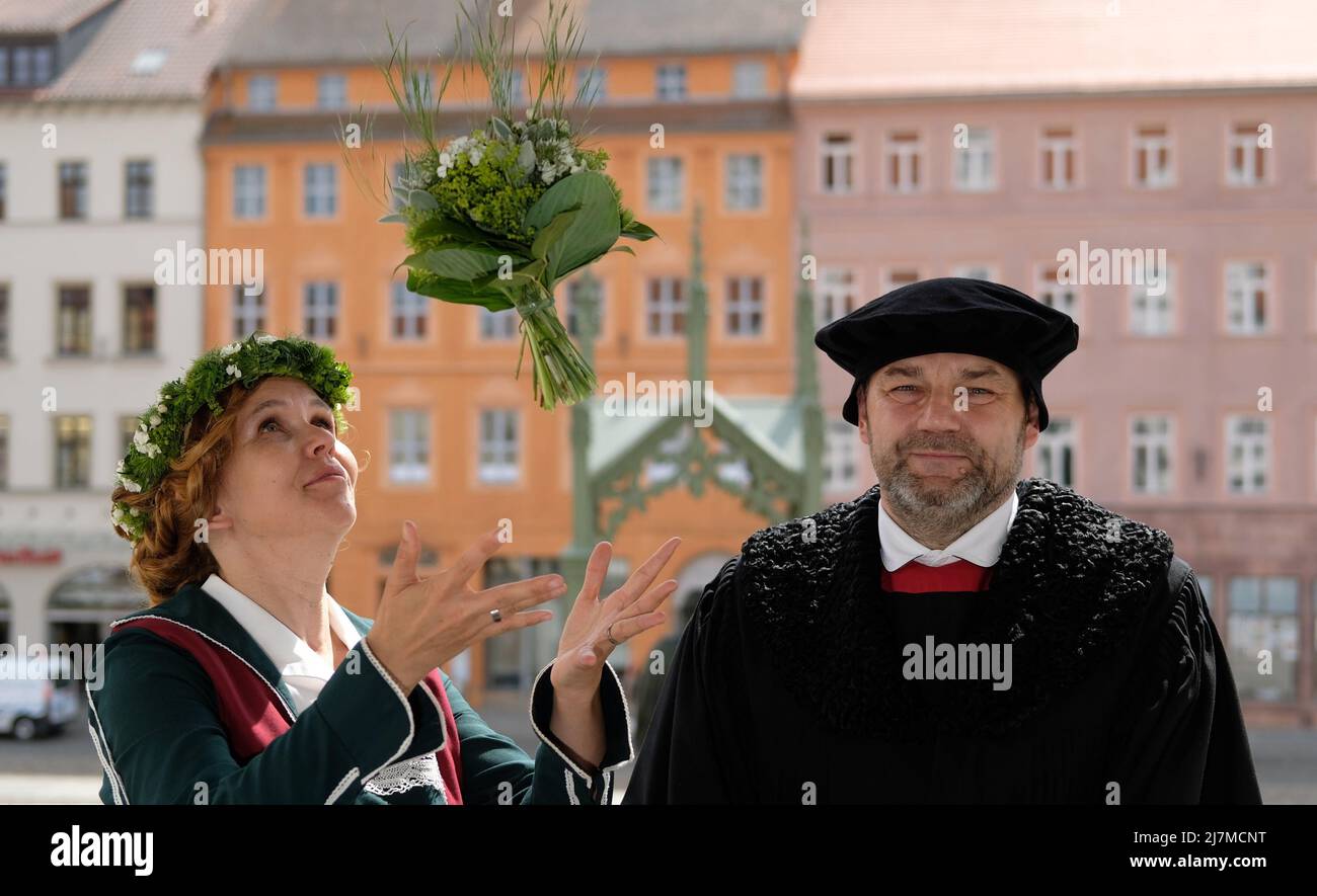 Lutherstadt Wittenberg, Deutschland. 10.. Mai 2022. Auf dem Balkon des Rathauses stehen Nicole Melzer-Fricke und Frank Moritz, Interpreten des Ehepaares Luther für das Wittenberger Stadtfest „Luthers Hochzeit“. Das Festival, das vom 10. Bis 12. Juni 2022 stattfindet, erinnert an die Hochzeit des ehemaligen Mönchs Martin Luther mit der Nonne Katharina von Bora im Jahr 1525. Jedes Jahr im Juni feiern Wittenberger und ihre Gäste dieses Fest als ihr großes Fest. Kredit: Sebastian Willnow/dpa/Alamy Live Nachrichten Stockfoto