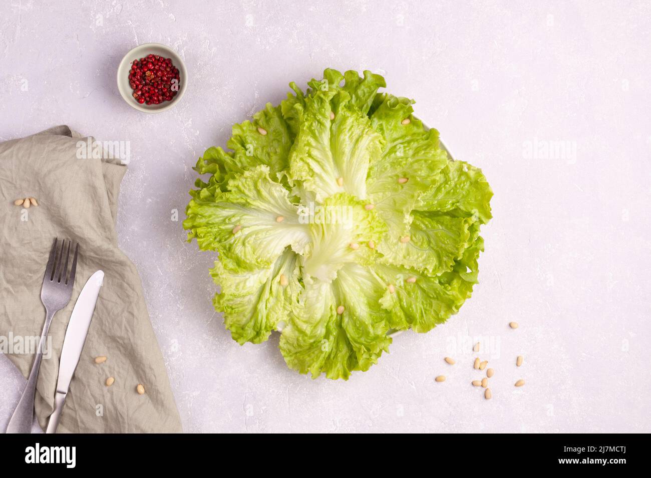 Frischer Bio-grüner Salat auf einem Teller serviert mit Pinienkernen und rotem Pfeffer Stockfoto