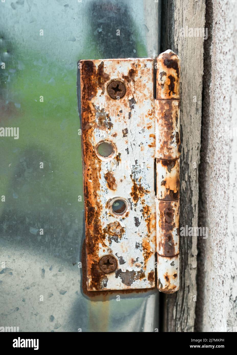 Nahaufnahme eines alten rostigen Scharniers an der Aluminiumtür. Stockfoto