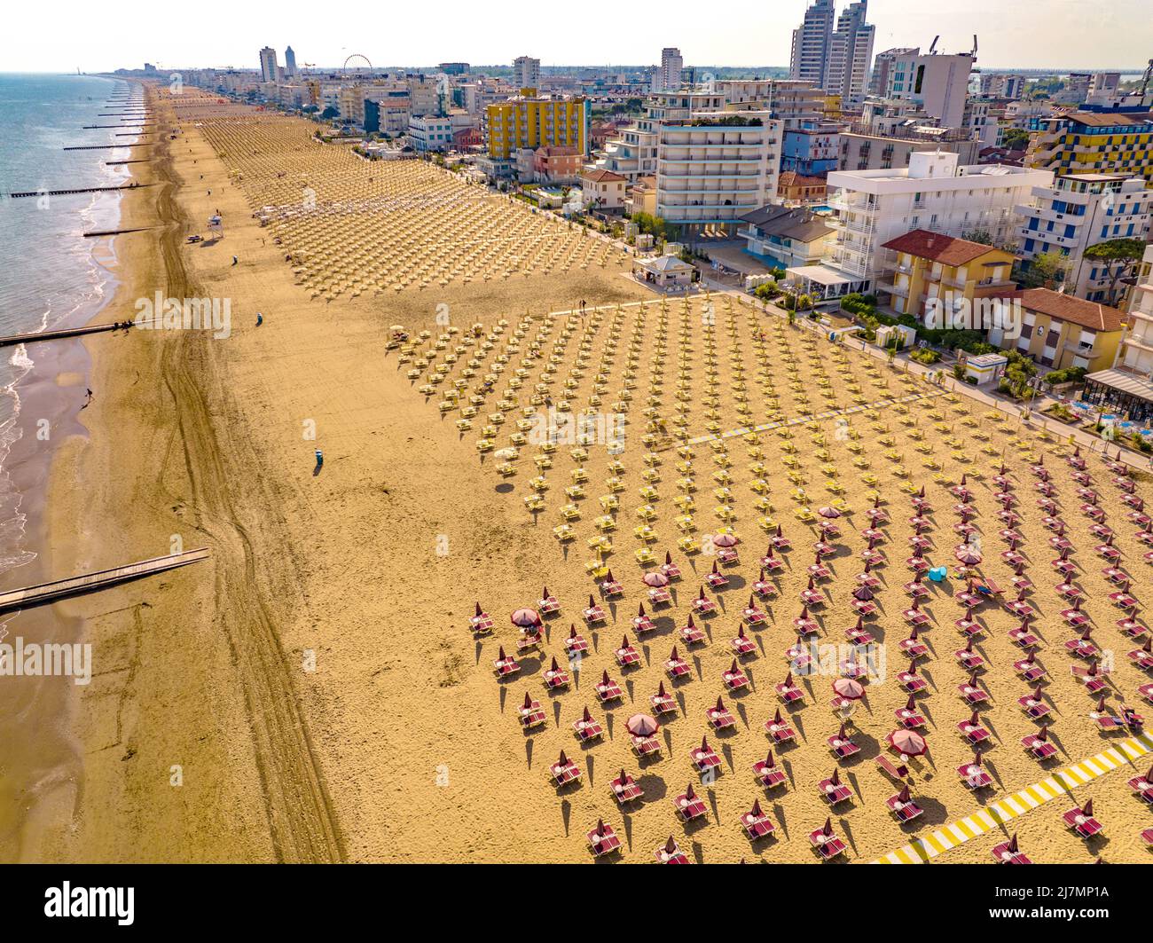 Spiaggia dorata di Jesolo con lettini solari,sedie sdraio e ombrelloni nella città italiana vista dall'alto durante un giorno soleggiato con Mare calm Stockfoto