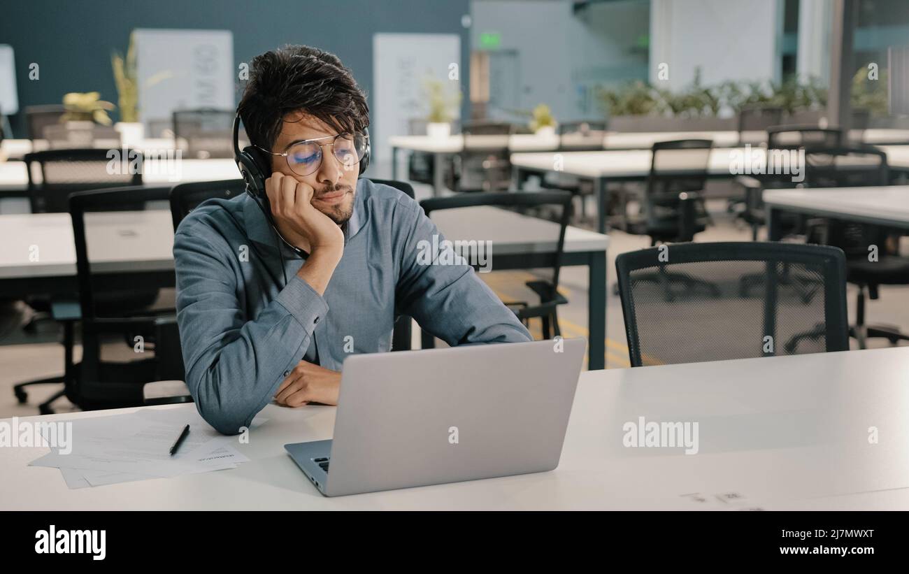 Gelangweilter Mann arabischer Mann indischer Servicemanager in Kopfhörern haben unzufrieden Look Videokonferenz Webinar Sprache lernen Verbesserung der Selbstbildung Stockfoto