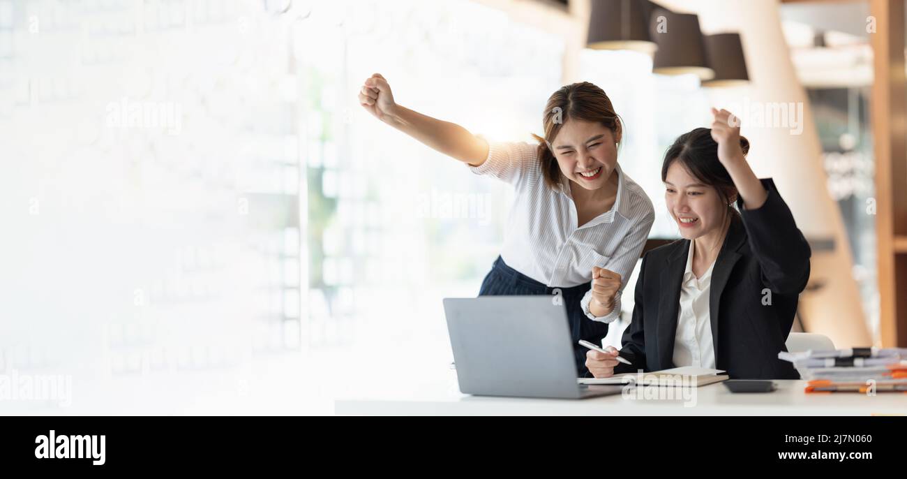 Zwei asiatische Frauen begeisterten Business-Team feiern Unternehmenssieg zusammen im Amt Stockfoto