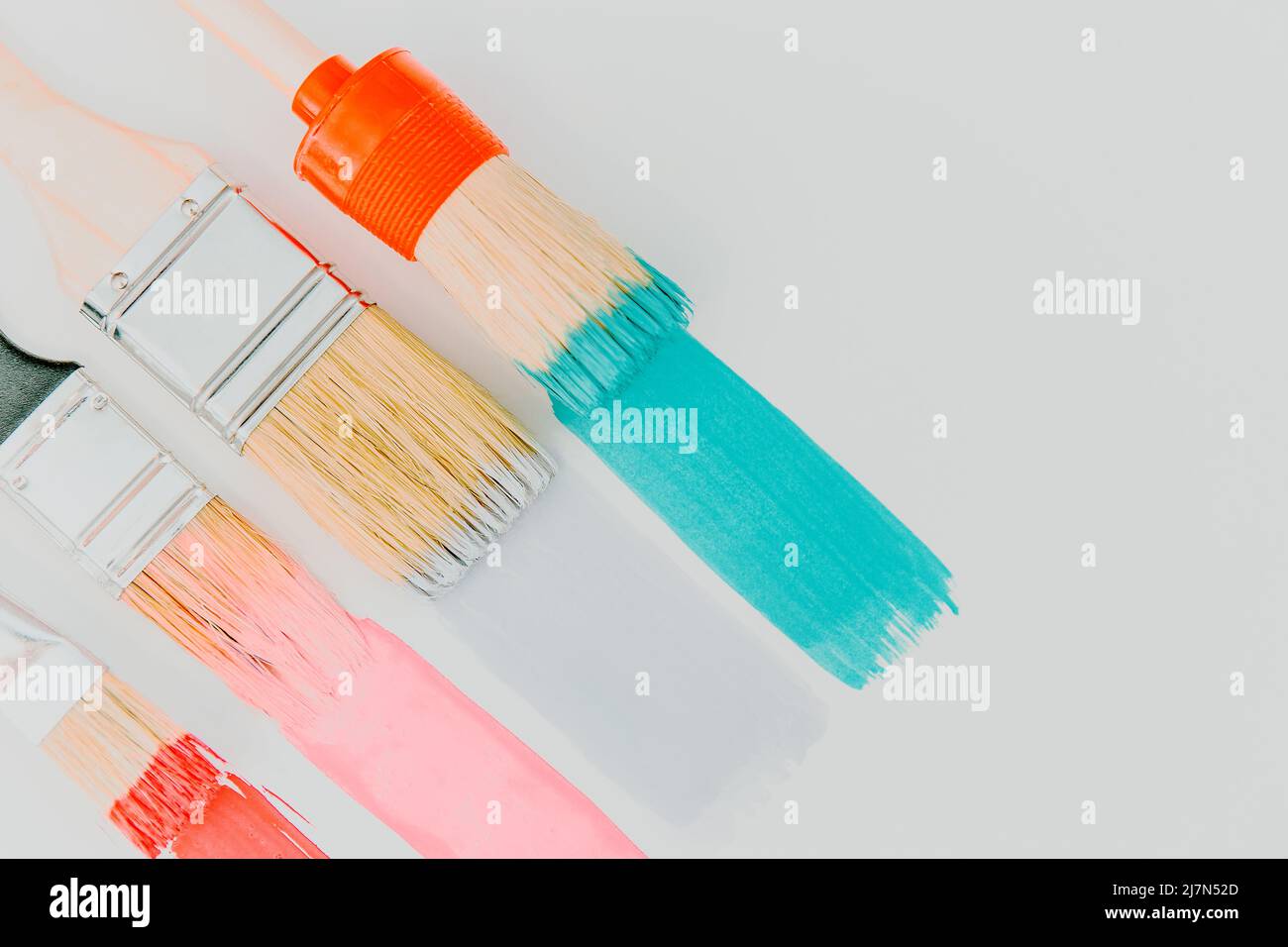 Künstlerischer Hintergrund. Pinsel malen bunte Pinselstriche auf hellem Hintergrund. Trendige Pastellrosa und Minzfarben von Farbschlägen Stockfoto