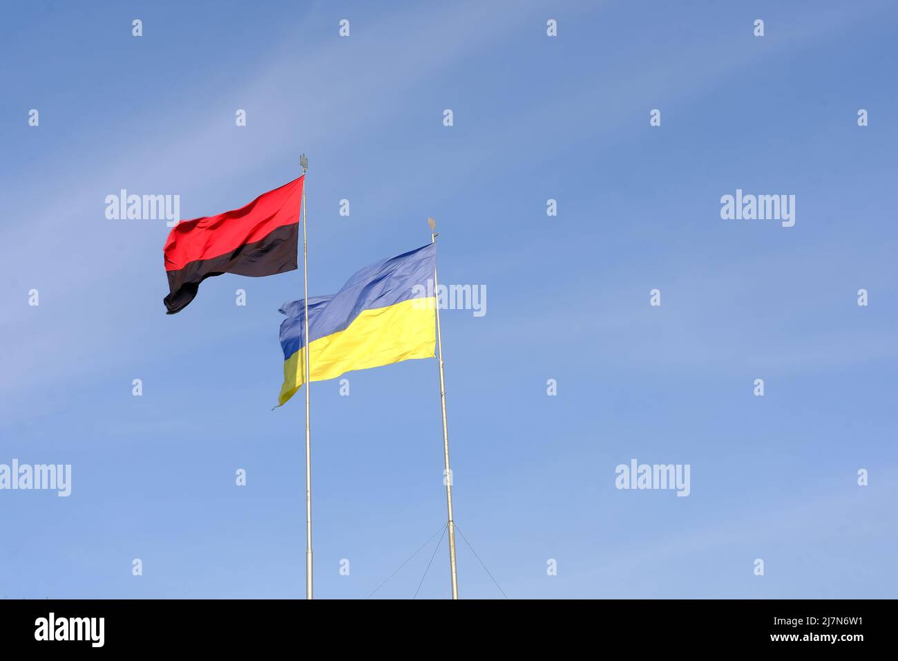 Ukrainische Flagge auf blauem Himmel hinten zusammen mit der Flagge der ukrainischen aufständischen Armee Stockfoto