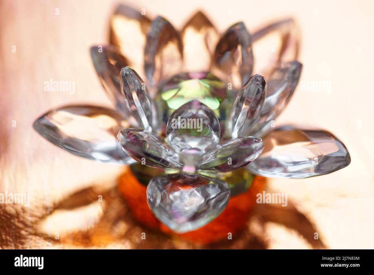 Kristalllotus auf rotem Tisch mit Lichtreflexion. Muladhara-Chakra-Symbol. Esoterische, reiki-Energie, Meditation, spirituelle Heilung. Stockfoto