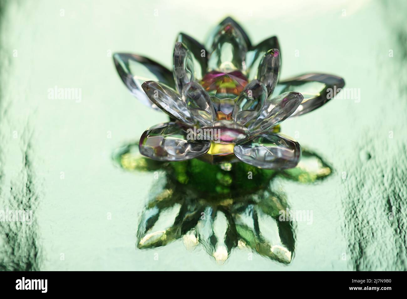 Kristalllotus auf glänzend grünem Hintergrund mit Lichtreflexion. Anahata Chakra-Symbol. Stockfoto