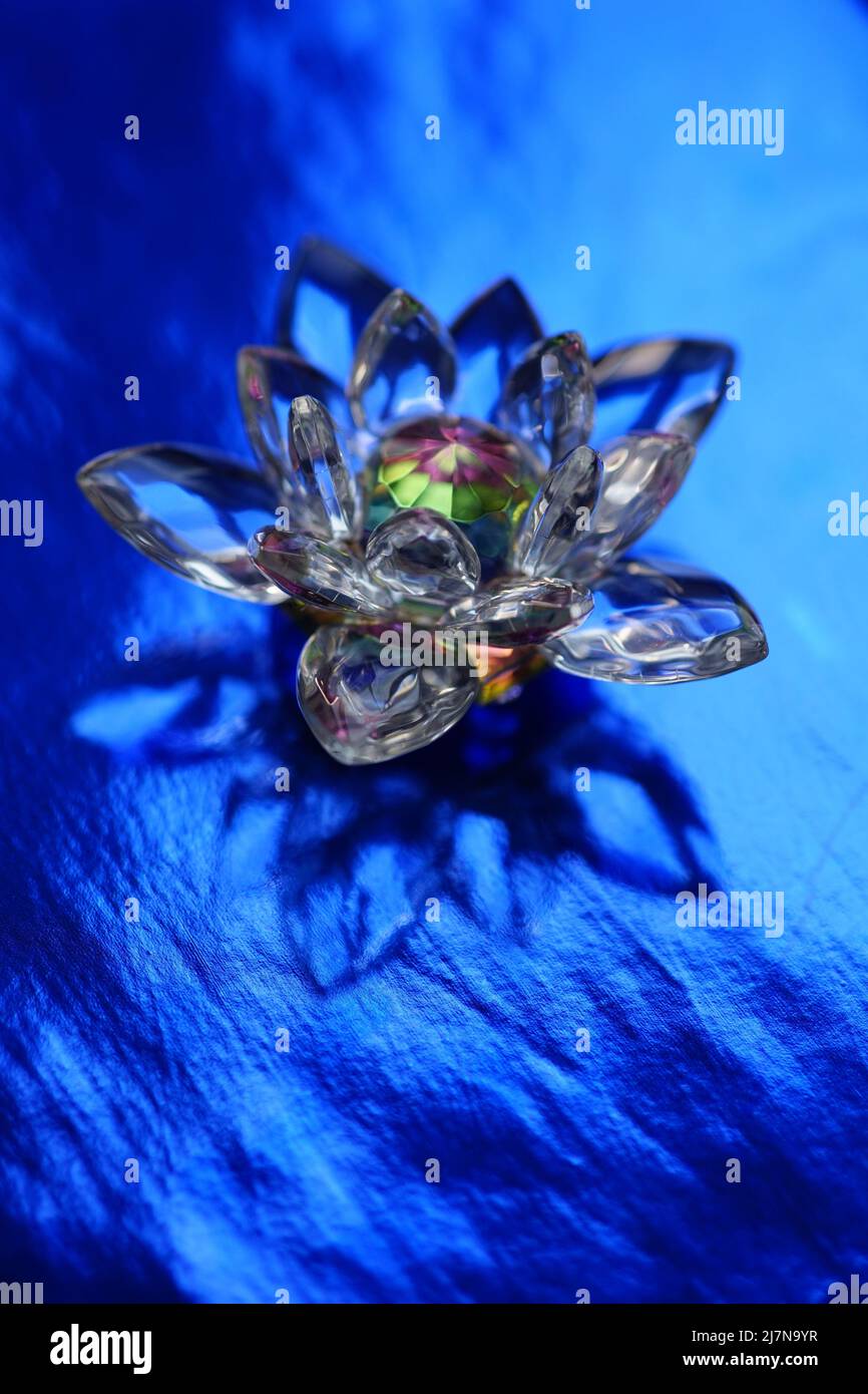 Kristalllotusblume auf glänzend dunkelblauem Tisch mit Spiegelung. Ajna-Chakra oder Symbol für das dritte Auge. Stockfoto