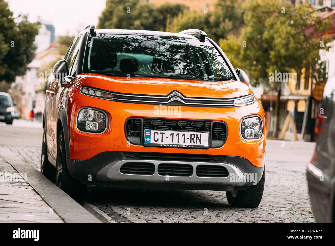 Orange, auf der Straße geparktes fahrzeug, das den flughafen C3 aircross hat Stockfoto