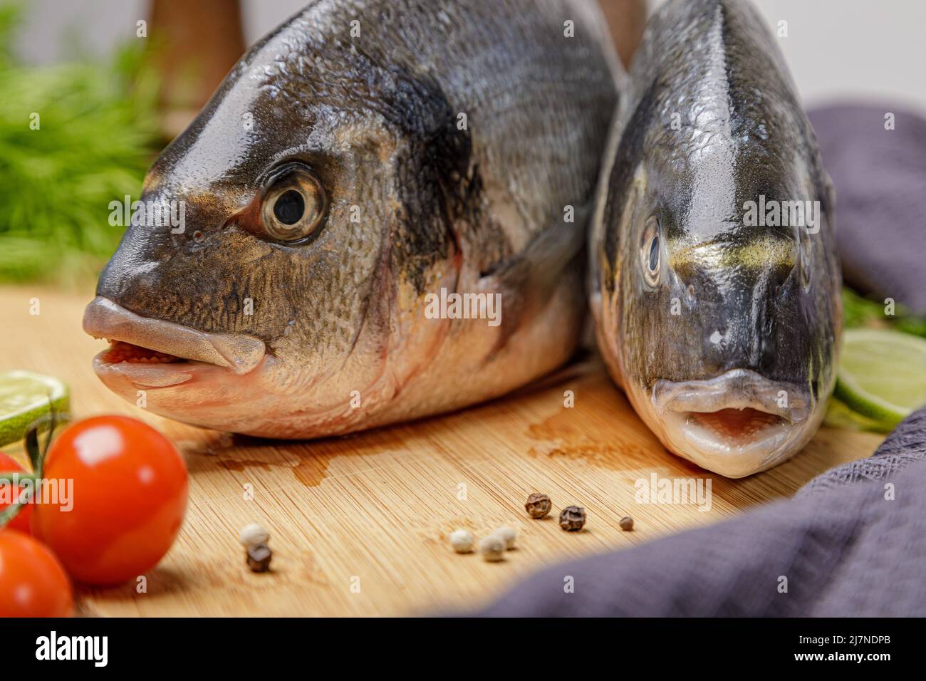 Frischer dorado-Fisch, auf einem Holzbrett, zwei Köpfe aus der Nähe. Stockfoto