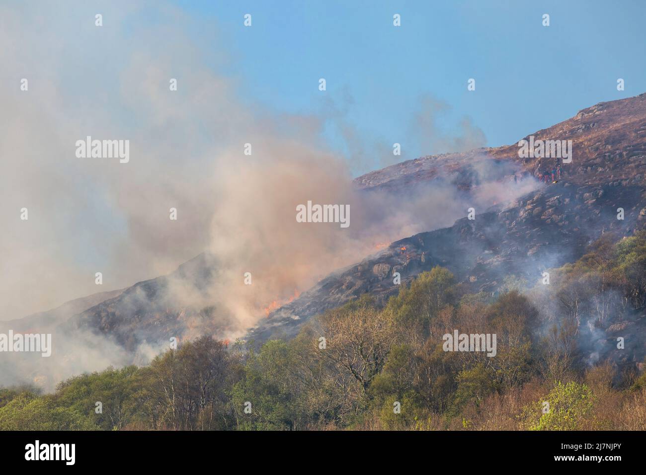 Editorial Schottland, Großbritannien - 22. April 2022: Feuerwehrleute in Morar in Schottland versuchen, ein Grasfeuer auf einem Hügel zu kontrollieren. Stockfoto