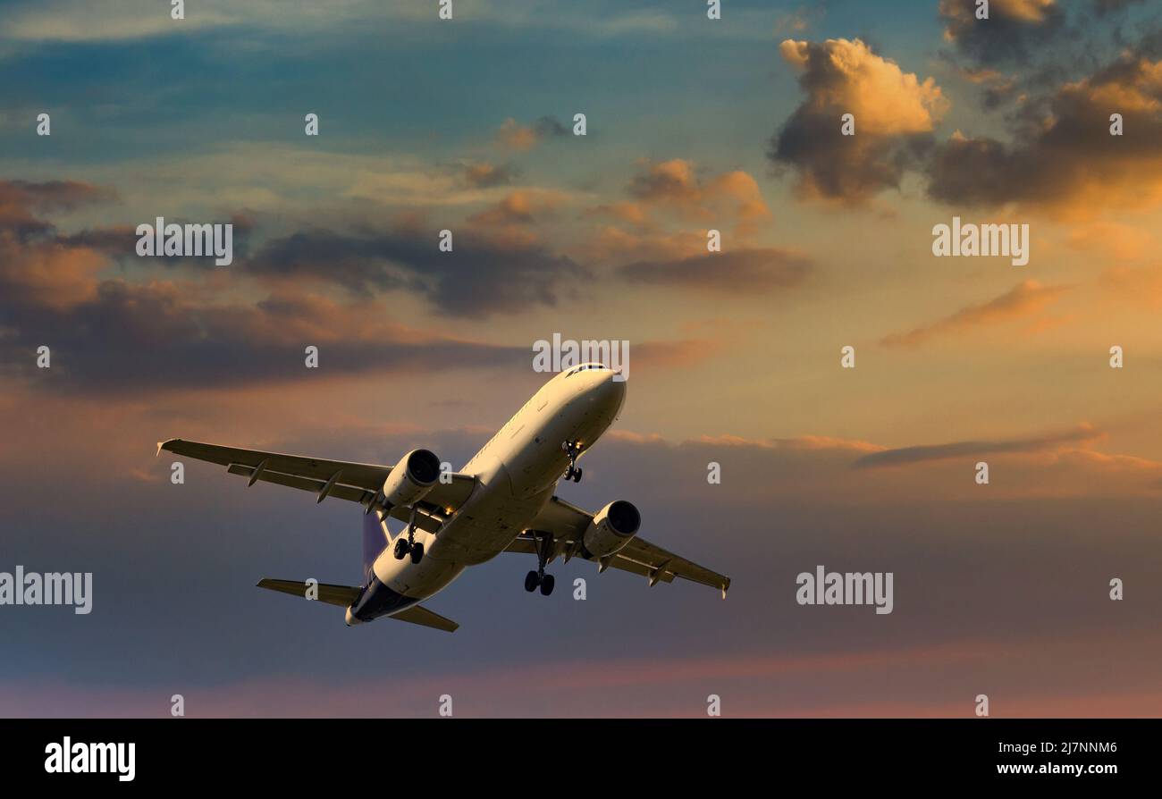 Passagierflugzeuge, die im Abendlicht unter den Wolken fliegen. Stockfoto