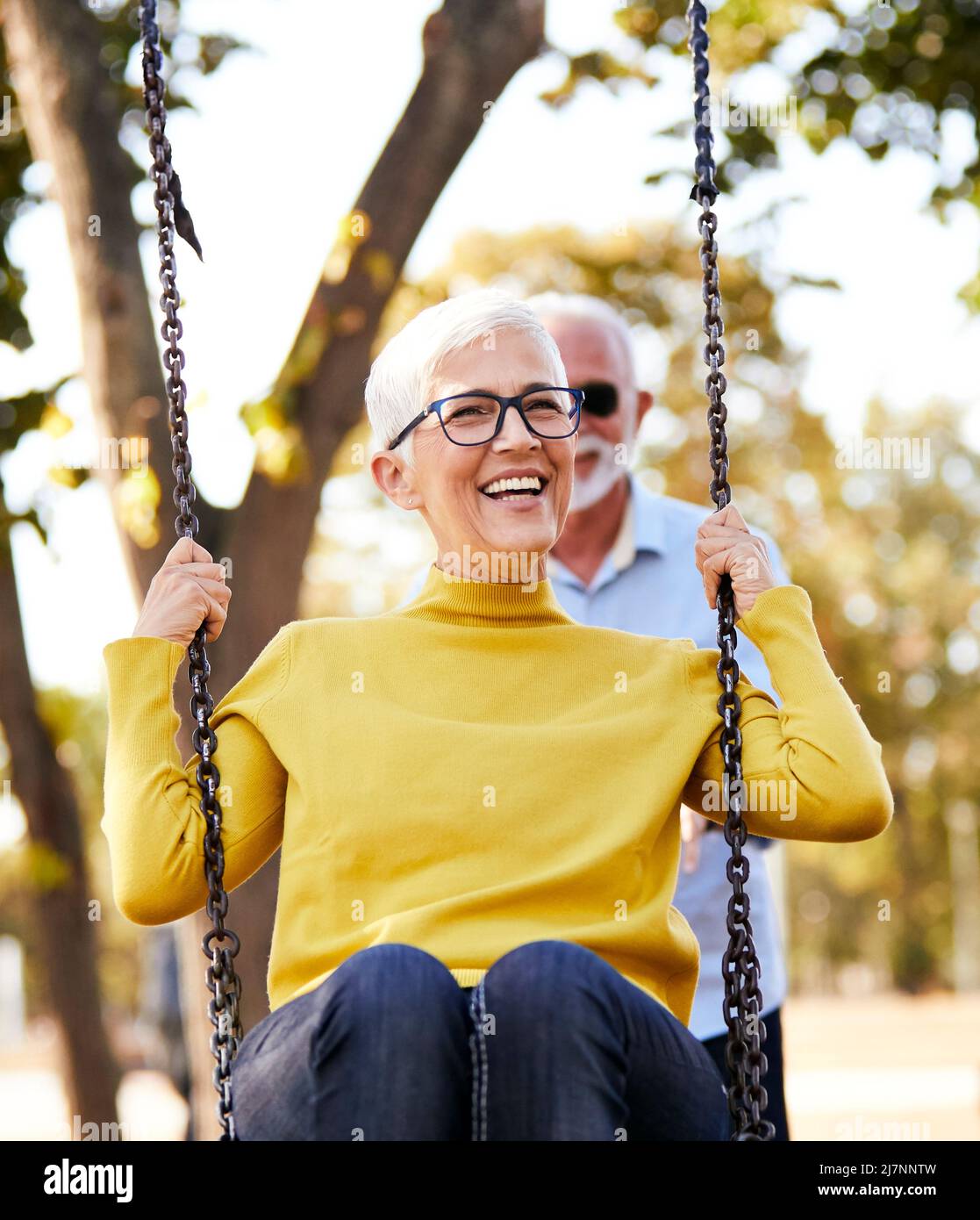 Seniorenpaar glücklich Schaukel Park Liebe aktiv gesund Lebensstil glücklich Spaß Freizeit Stockfoto