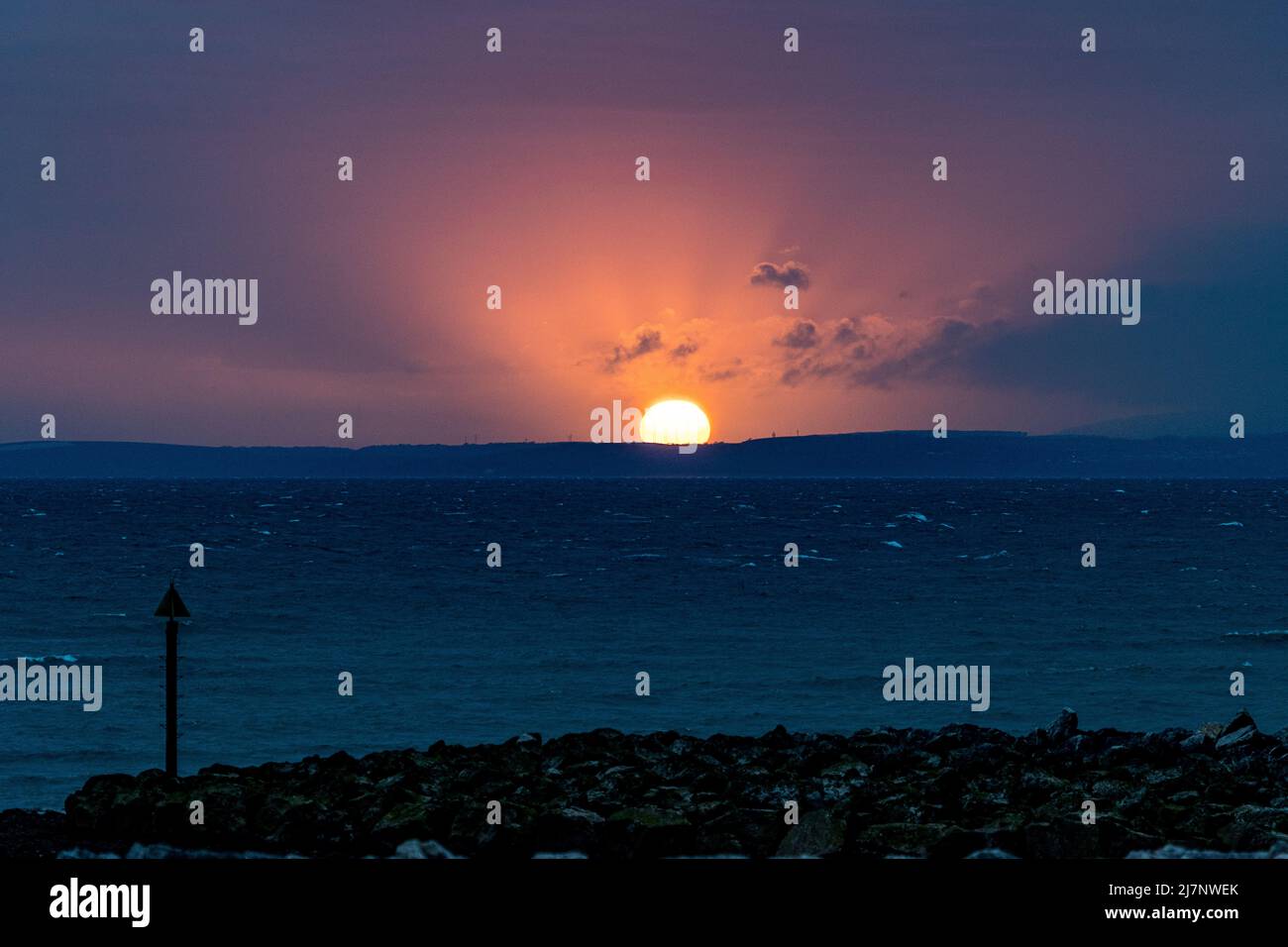 Morecambe Lancashire, Großbritannien. 10.. Mai 2022. Die Sonne bricht nach dem bewölkten Ende des Tages durch die Wolken und sorgt für einen spektakulären Sonnenuntergang über der Morecambe Bay. Quelle: PN News/Alamy Live News Stockfoto