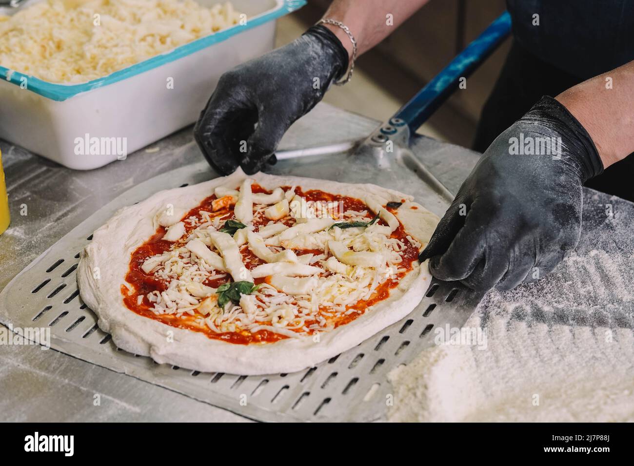 Ein Koch, der sich auf neapolitanische Pizzen spezialisiert hat, bereitet den Teig vor Stockfoto