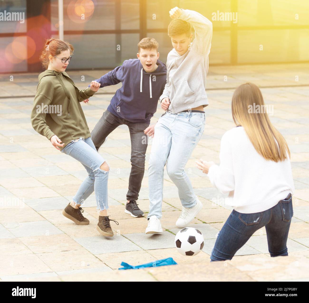 Jugendliche spielen Fußball mit Ball draußen Stockfoto