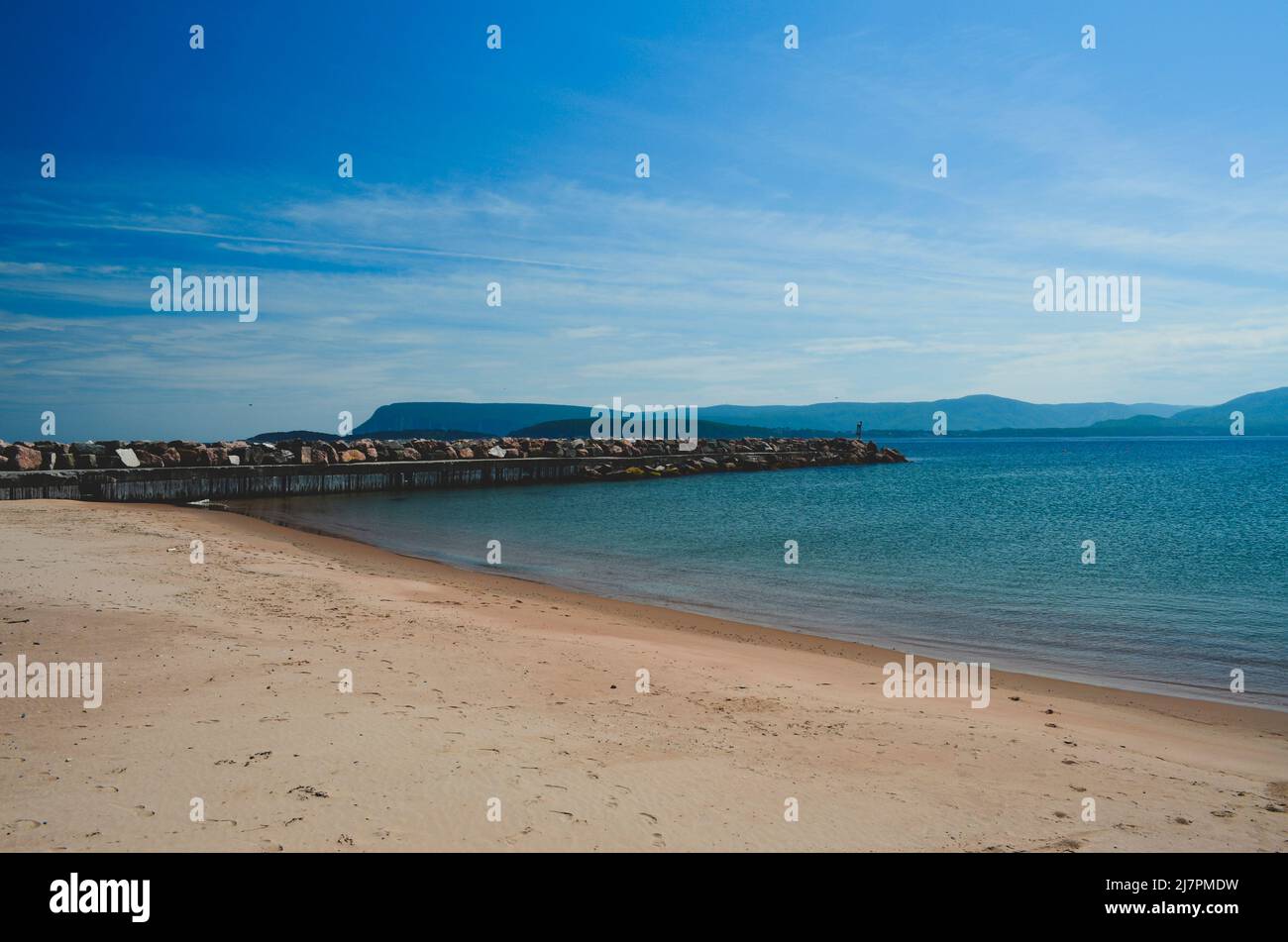 Landschaftlich schöner Strand und Felsmauer mit Bergen im Hintergrund. Sommertag in Nova Scoita Kanada. Stockfoto