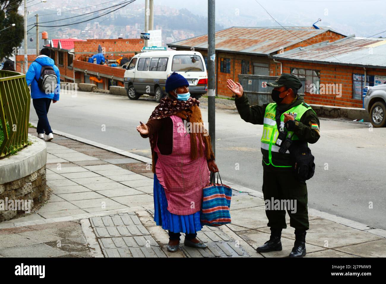 Eine Polizistin gibt den älteren Frauen in La Ceja, El Alto, Bolivien, Anweisungen Stockfoto