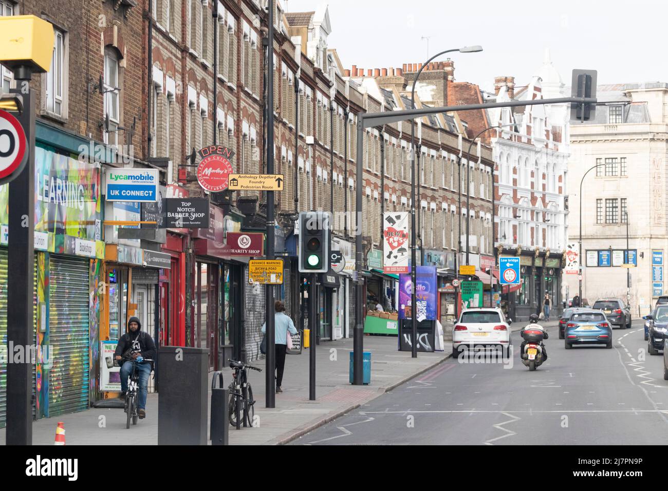 Blick auf die New Cross Road in London, England, tagsüber über über über Geschäfte, Fußgänger und Verkehr. Stockfoto