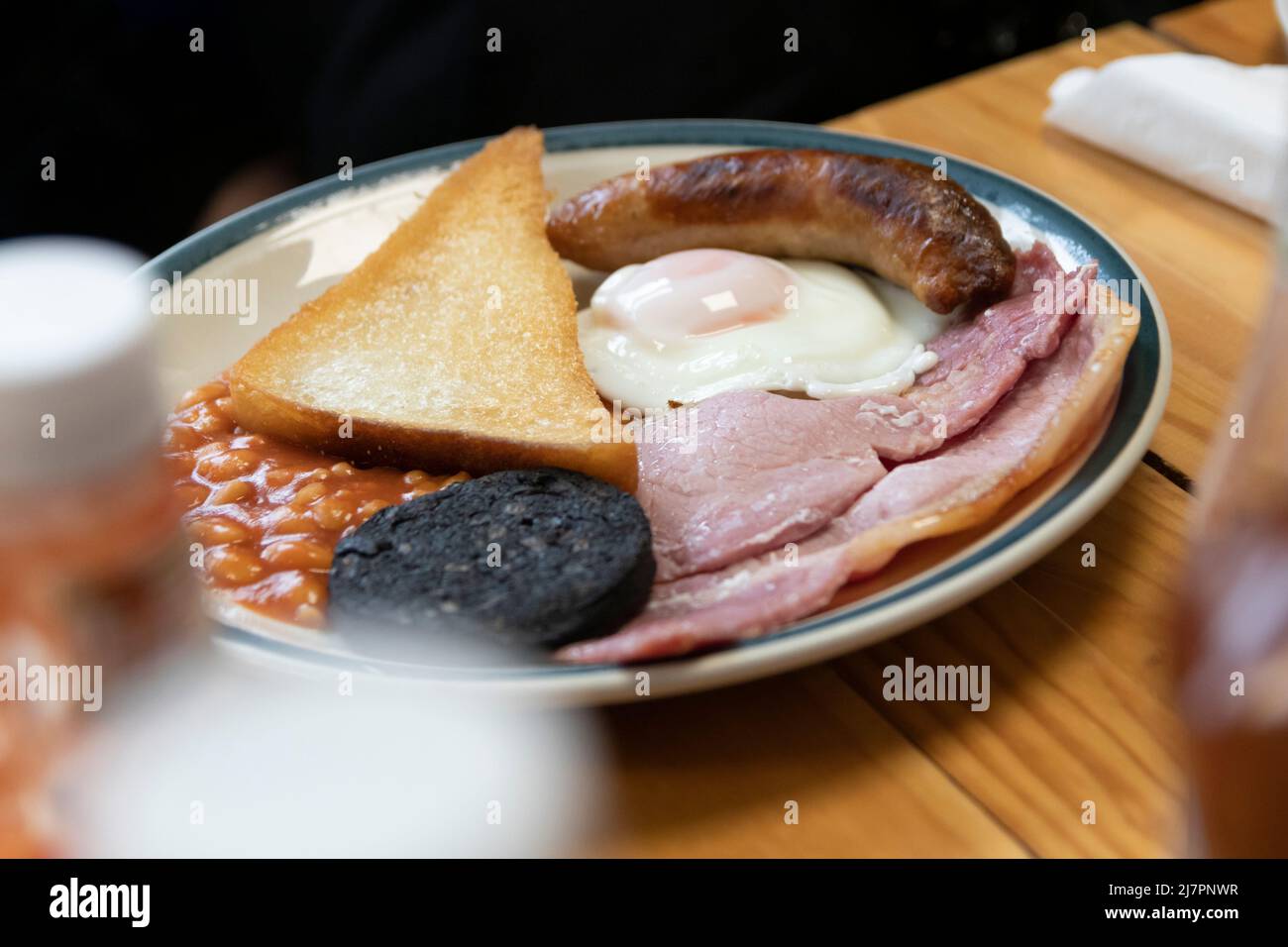 Komplettes englisches Frühstück - auch bekannt als „Fry-up“ - bestehend aus Eiern, Wurst, Speck, Bohnen, Toast, Und Blutwurst. Stockfoto