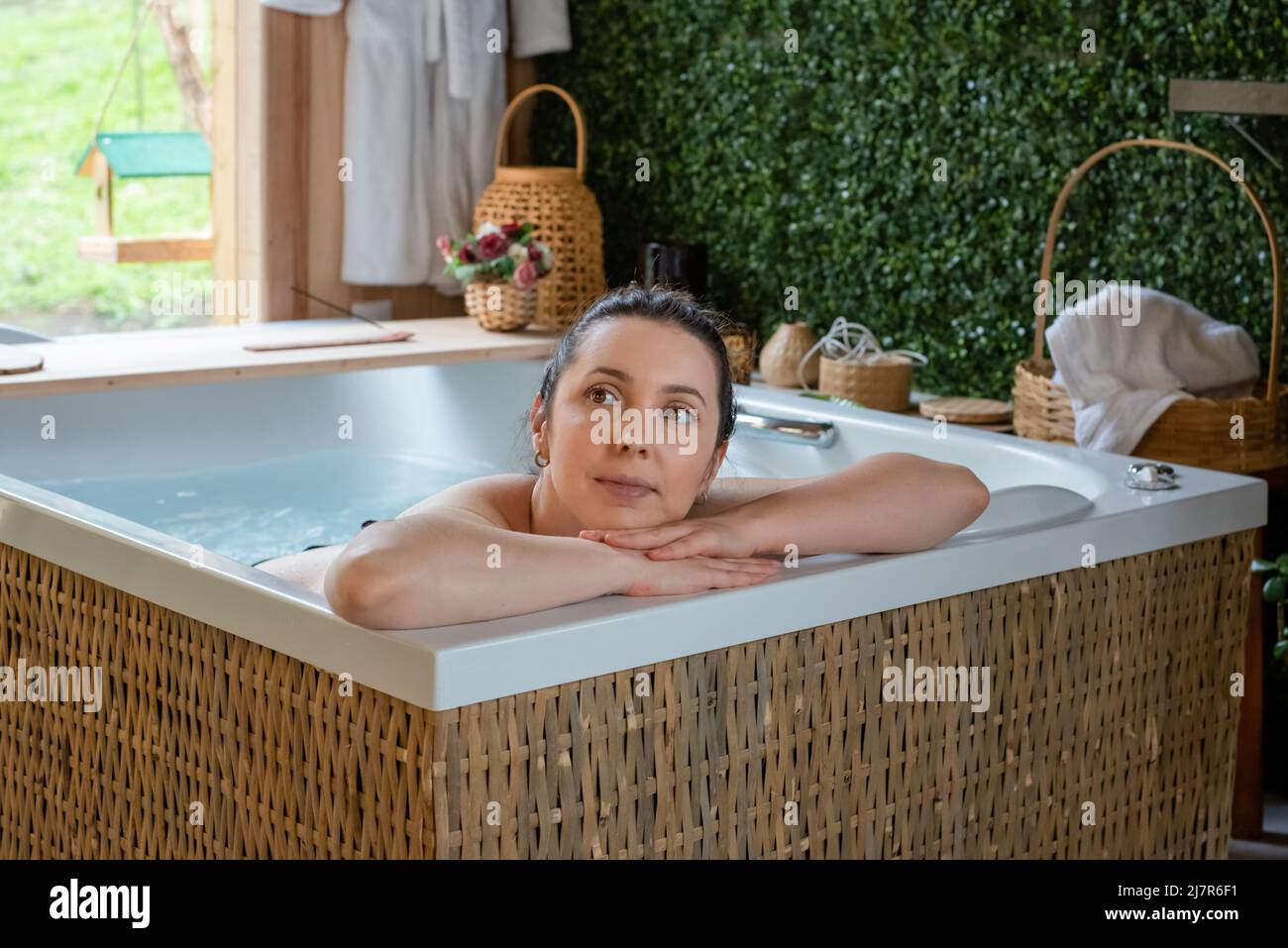 Rücksichtsvolle Frau, die ihren Kopf in den Händen im Whirlpool ruht Stockfoto