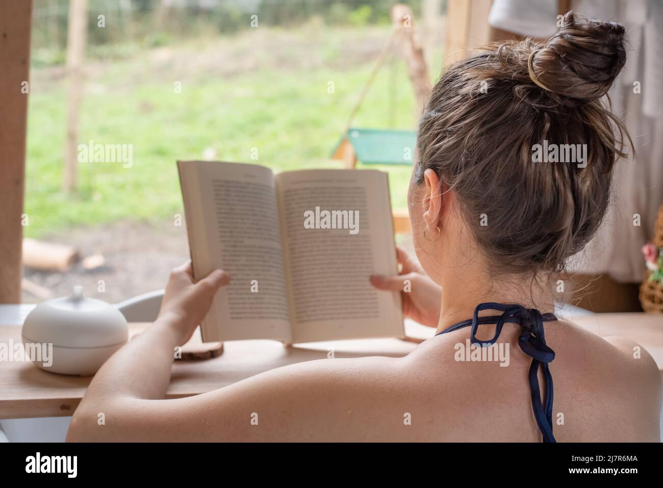 Entspannte Frau, die ein Buch im Whirlpool liest Stockfoto
