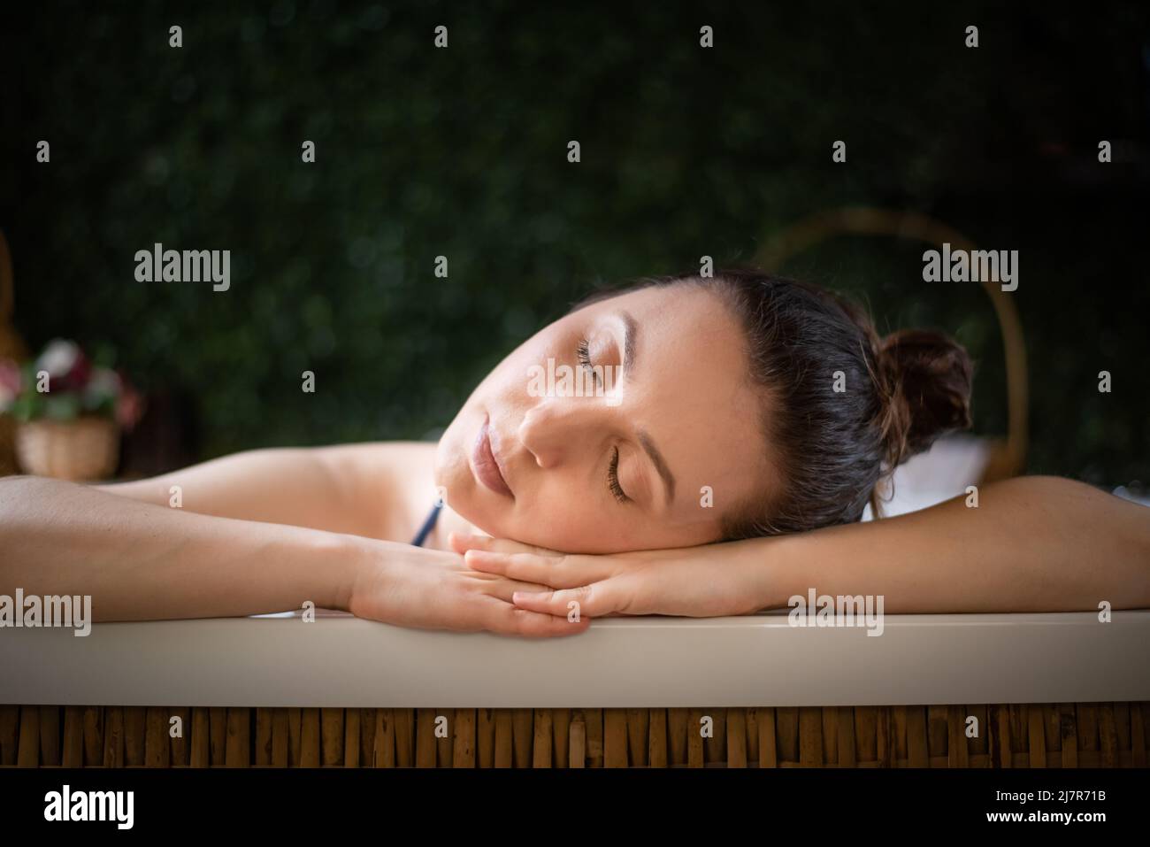 Entspannte Frau, die Kopf in den Händen im Whirlpool ruht Stockfoto