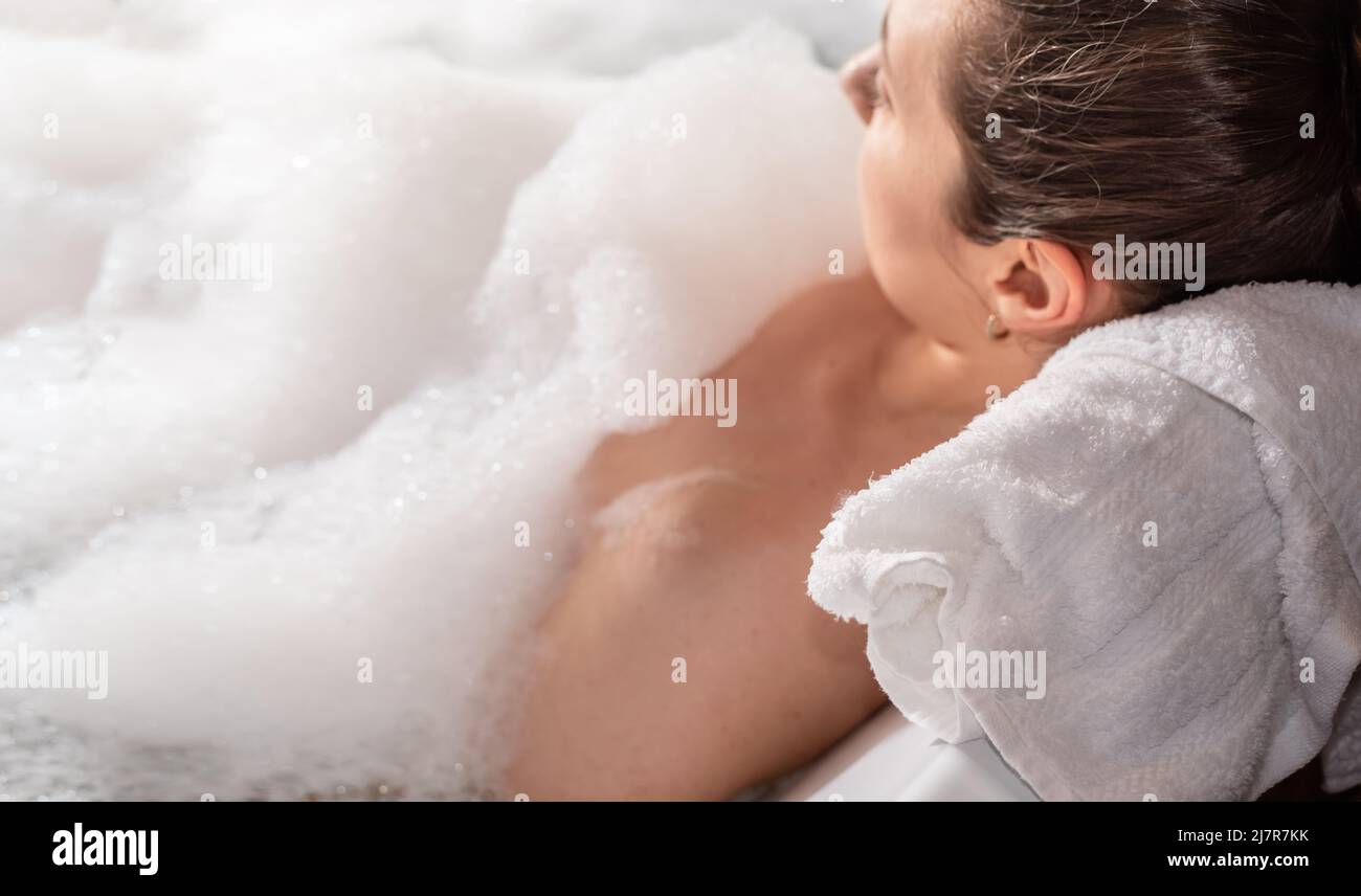 Eine Frau, die sich im Whirlpool mit Seifenschaum entspannen konnte Stockfoto