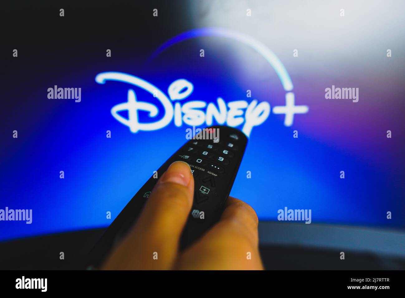 Brasilien. 10.. Mai 2022. In dieser Abbildung zeigt eine Nahaufnahme einer Hand, die eine Fernbedienung hält, die vor dem Disney Plus-Logo auf einem fernsehbildschirm zu sehen ist. Kredit: SOPA Images Limited/Alamy Live Nachrichten Stockfoto