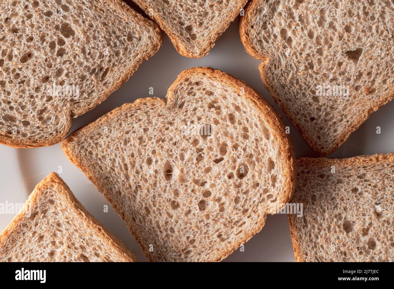 Scheiben braunes Brot aus Weizenmehl auf einem weißen Teller gebacken. Stockfoto