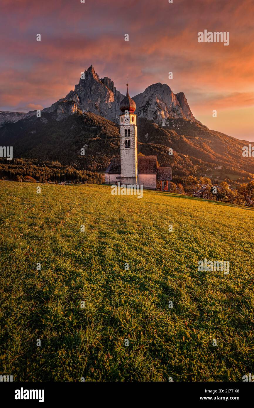 Seis am Schlern, Italien - wunderschöner Sonnenuntergang und idyllische Bergkulisse in den italienischen Dolomiten mit St. Valentin Kirche und dem berühmten Schlern mit Stockfoto