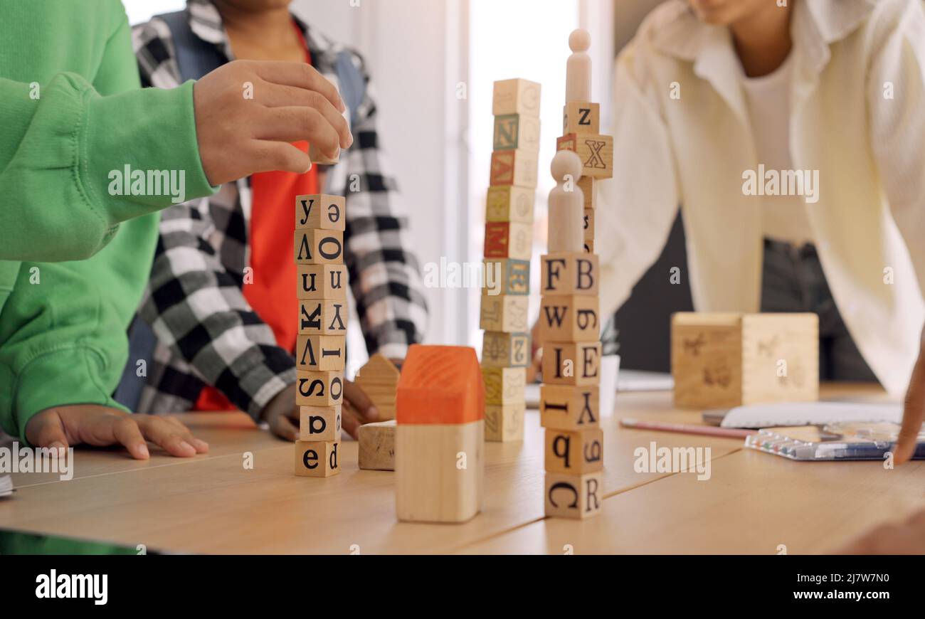 Afroamerikanische Lehrer und Schüler, die Aktivität spielen Block Holz für die Entwicklung zusammen mit genießen und Spaß im Klassenzimmer. Stockfoto