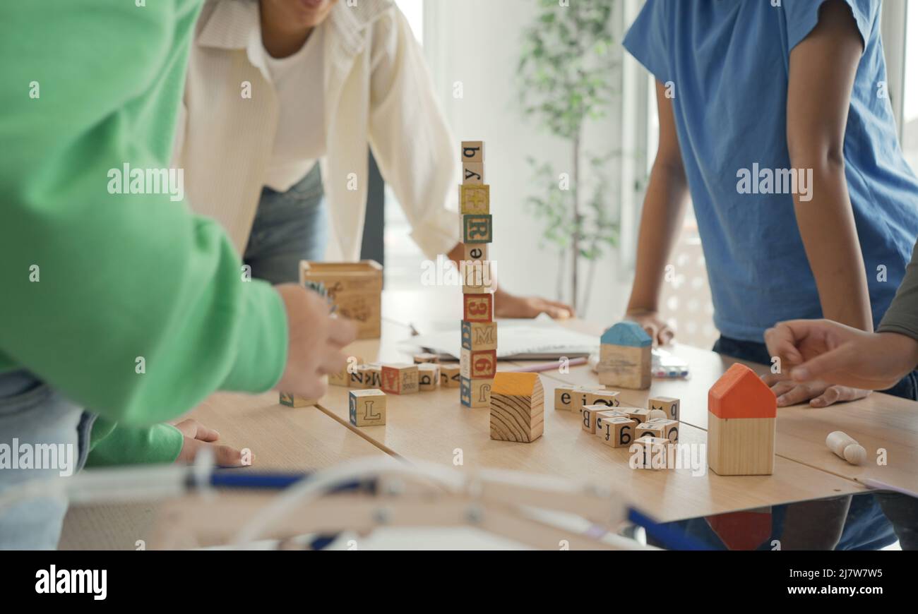 Afroamerikanische Lehrer und Schüler, die Aktivität spielen Block Holz für die Entwicklung zusammen mit genießen und Spaß im Klassenzimmer. Stockfoto