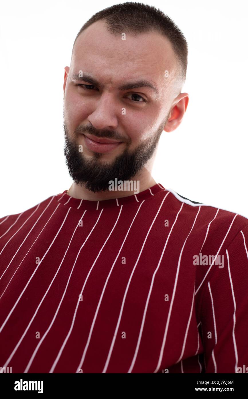 Vertikales Bild von unrasierten lächelnden Mann Gesicht, Grimassen und Blick auf die Kamera, mit Borsten. Augenbraue ironisch anheben Stockfoto