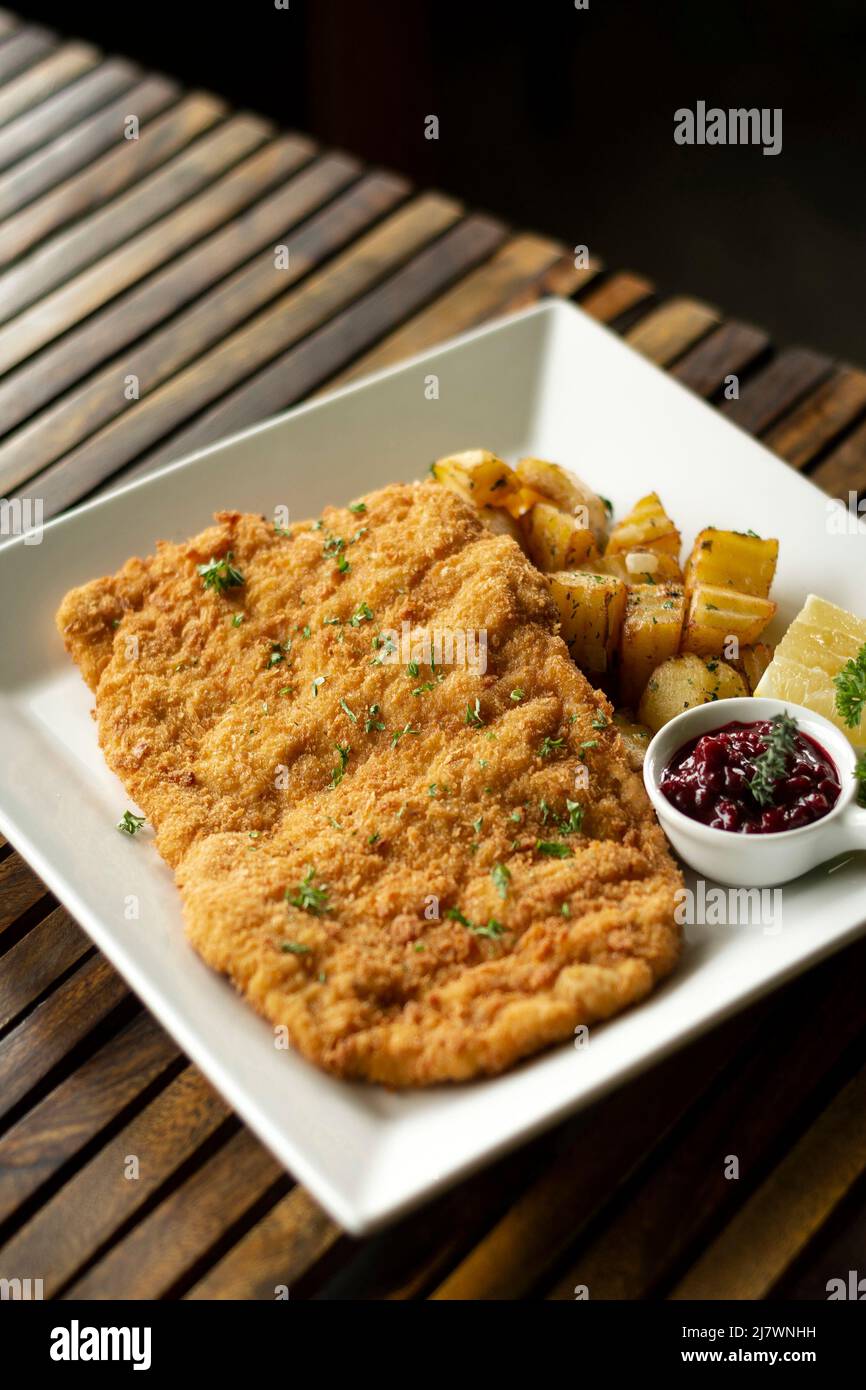 deutsches Kalbsschnitzel-Schnitzel mit Kartoffel- und Rotbeersoße im berliner Restaurant Stockfoto