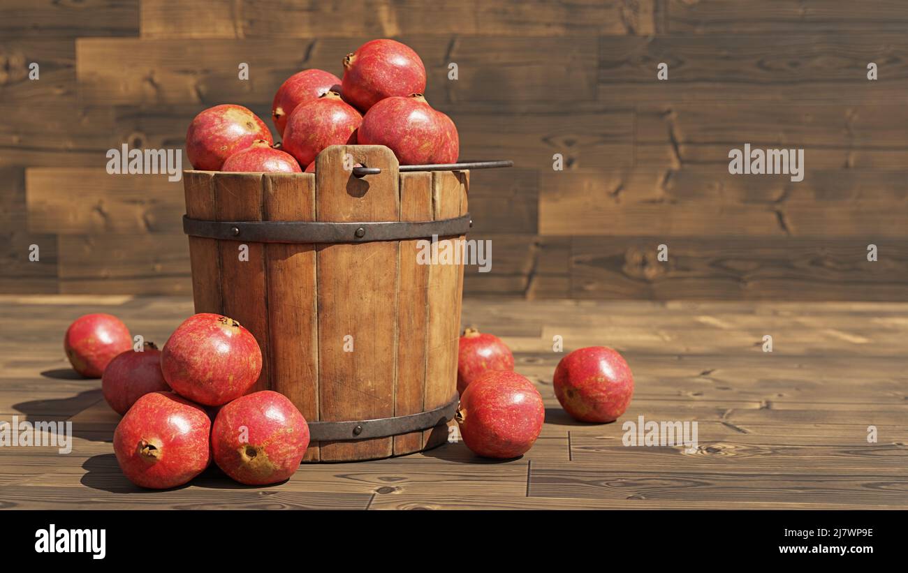 Granatäpfel, saftige Früchte in einem antiken Eimer auf Holzhintergrund Stockfoto