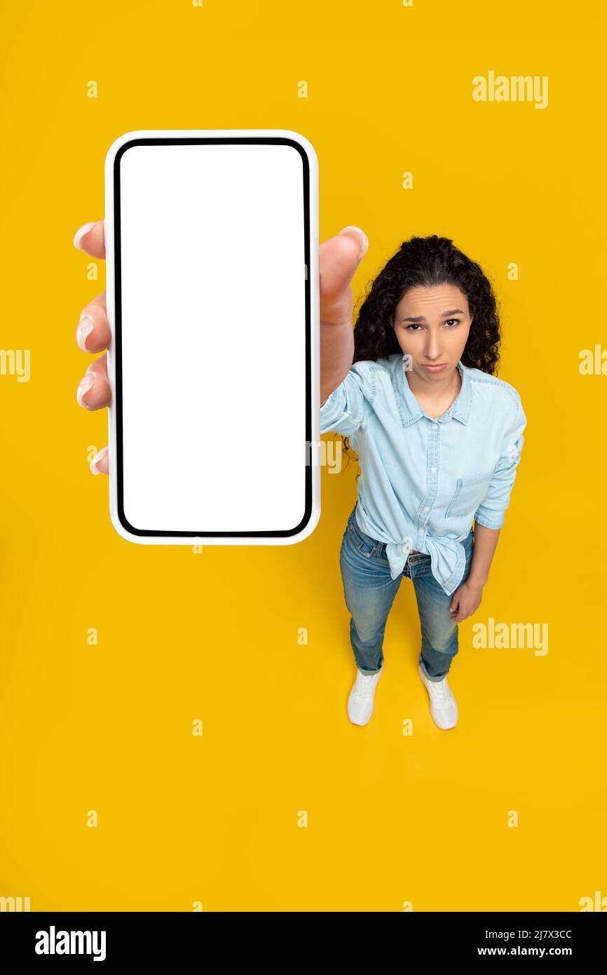 Traurige Dame mit leerem Smartphone-Bildschirm Stockfoto