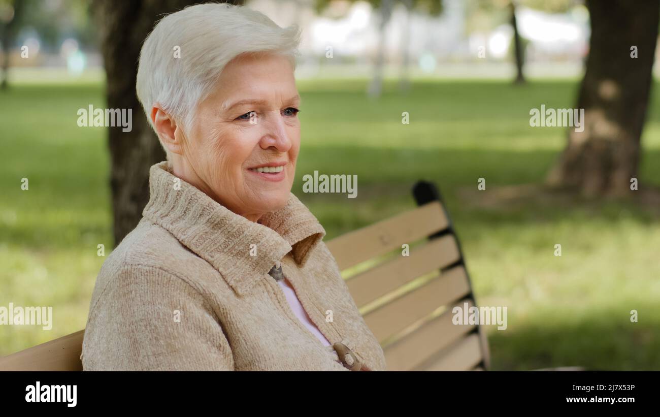 Nahaufnahme faltiges Gesicht von 65s glücklichen älteren Frau im Freien Blick beiseite mit breiten Lächeln, Zahnimplantate und Prothesen zufrieden Kundenporträt Stockfoto